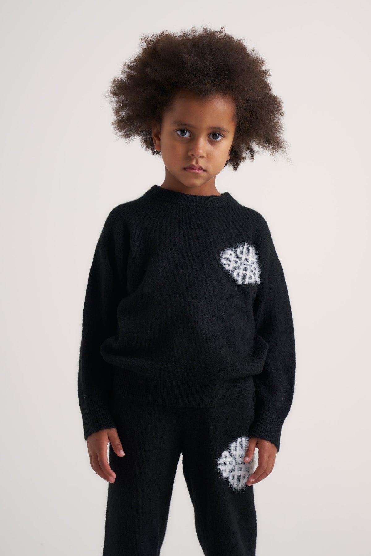 Kids Emblem Fluffy Knit Crew in Black – model front view styled with the matching joggers