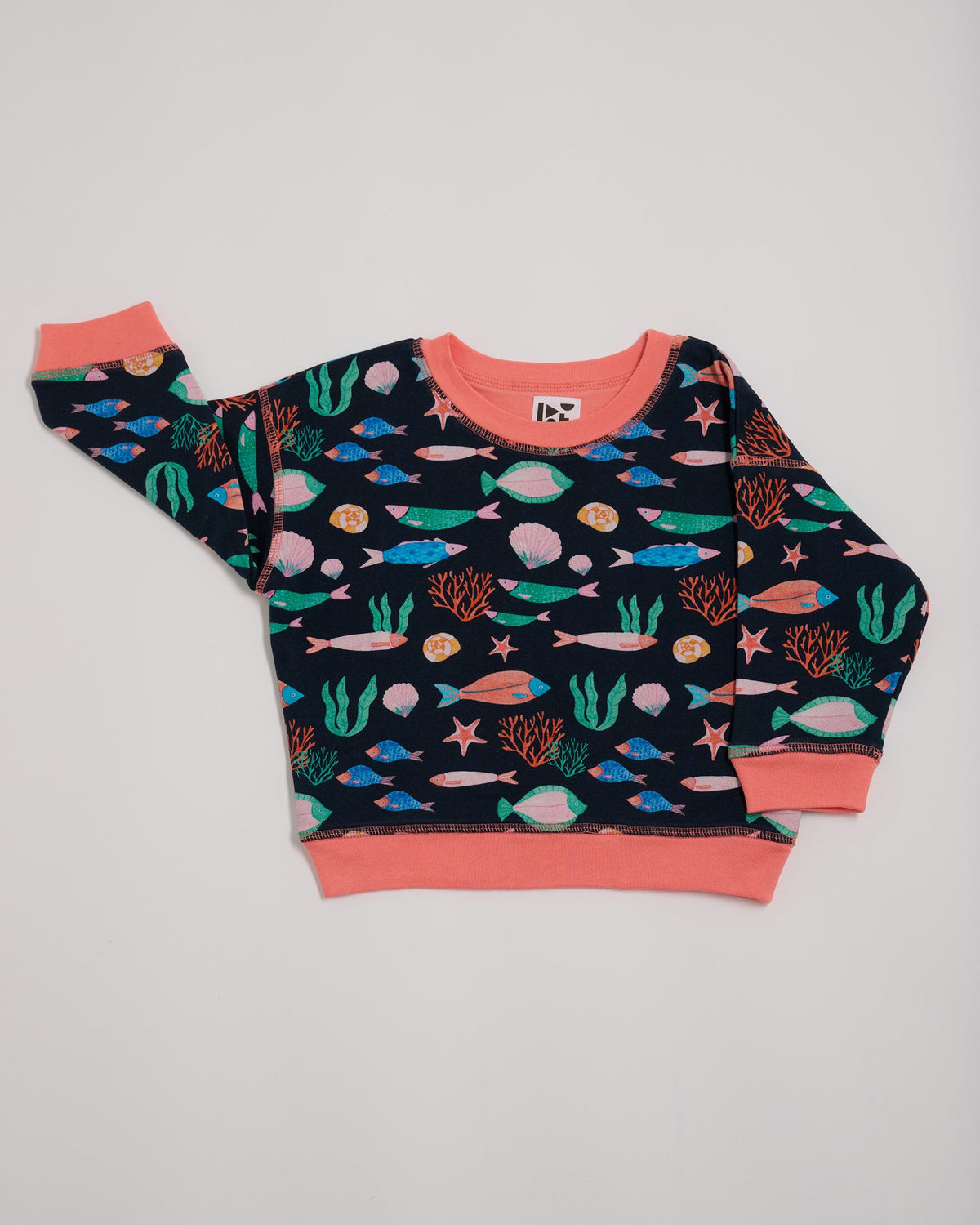 Front of sweatshirt featuring an all over vibrant navy fish print with contrast coral neck and sleeve trim.