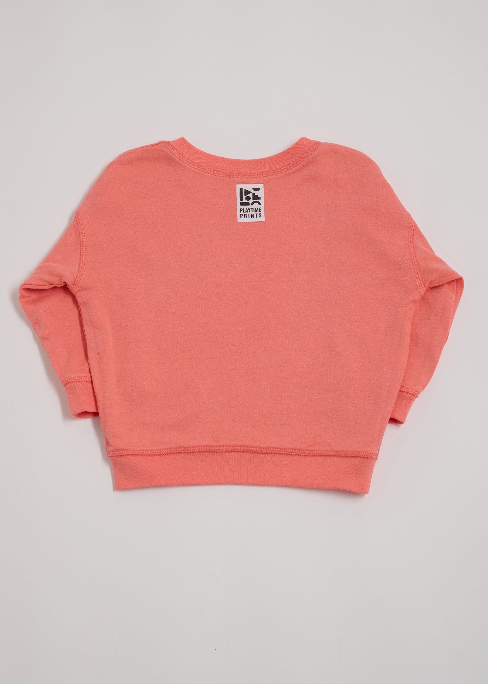Back of coral sweatshirt showing Playtime Prints brand label.
