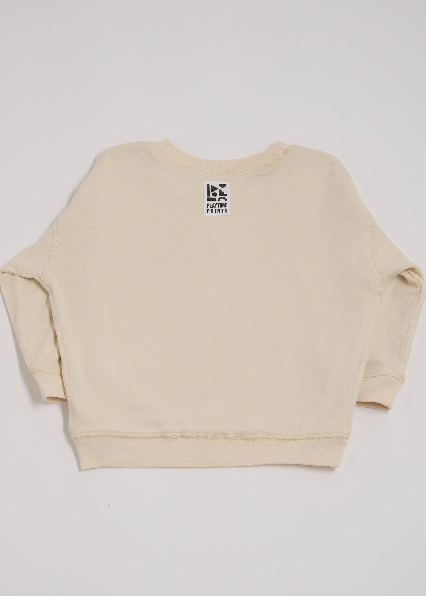 Back of ecru sweatshirt showing Playtime Prints brand label.