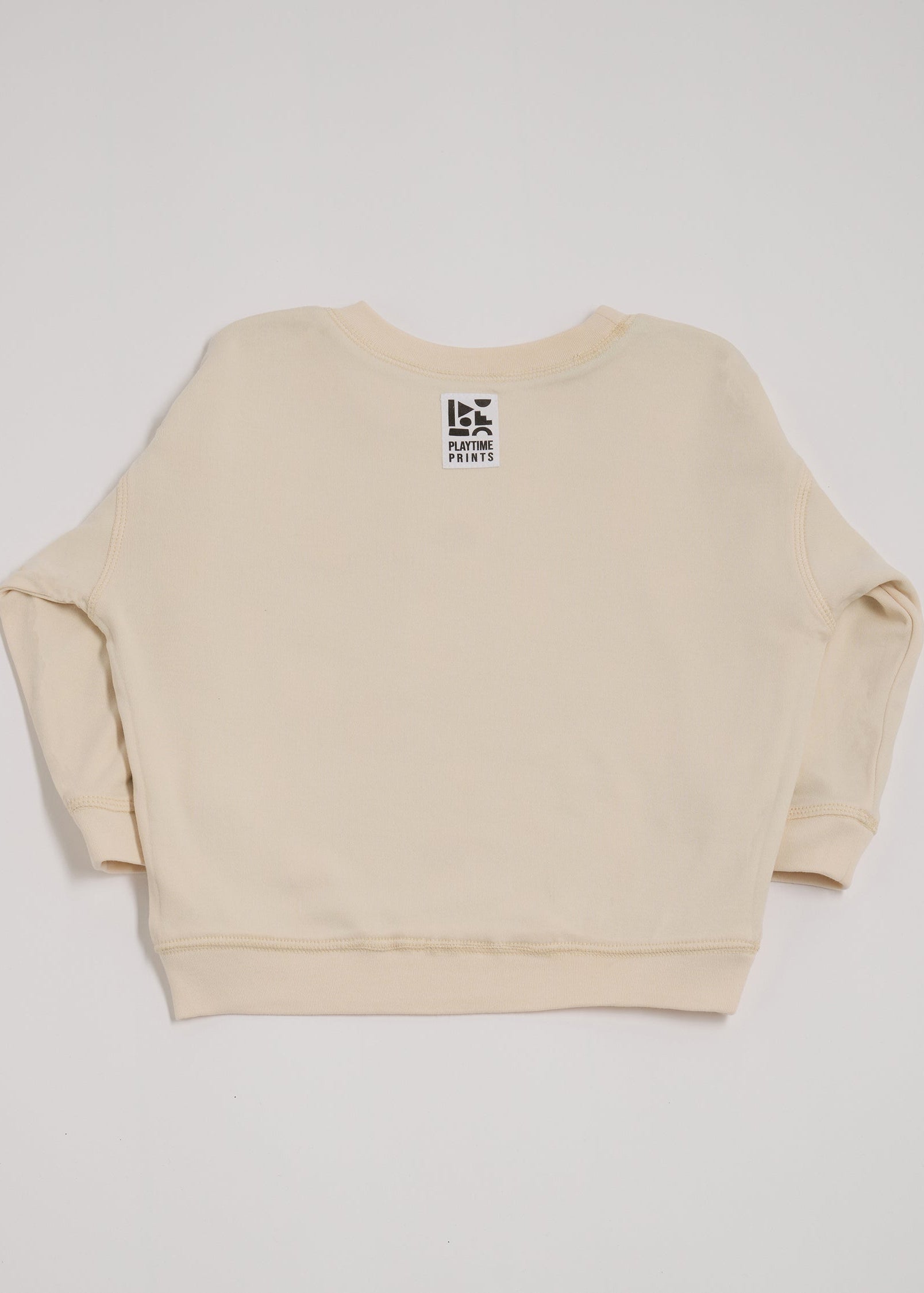 Back of ecru sweatshirt showing Playtime Prints brand label.