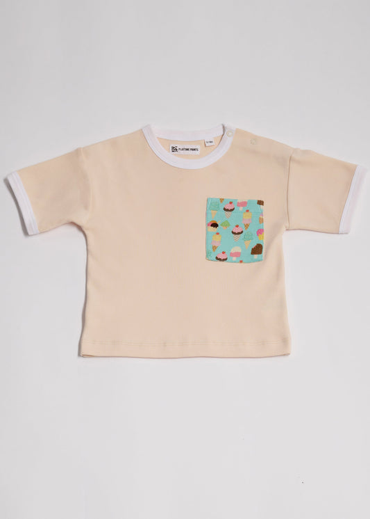Front of vanilla coloured short sleeved t-shirt with bright ice cream print square chest pocket, neck poppers and white neck and sleeve trim.