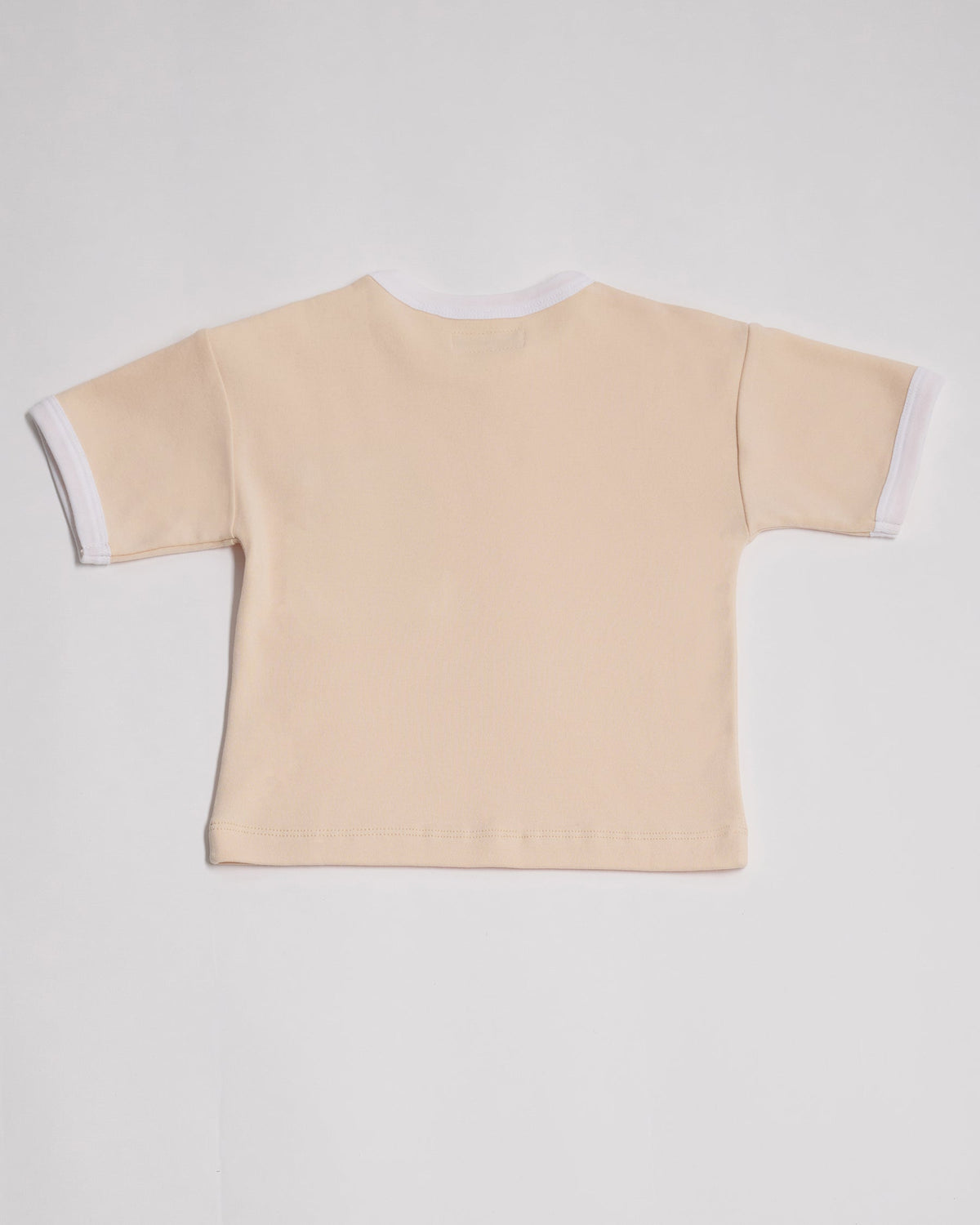Back of vanilla coloured short sleeved t-shirt with white neck and sleeve trim.