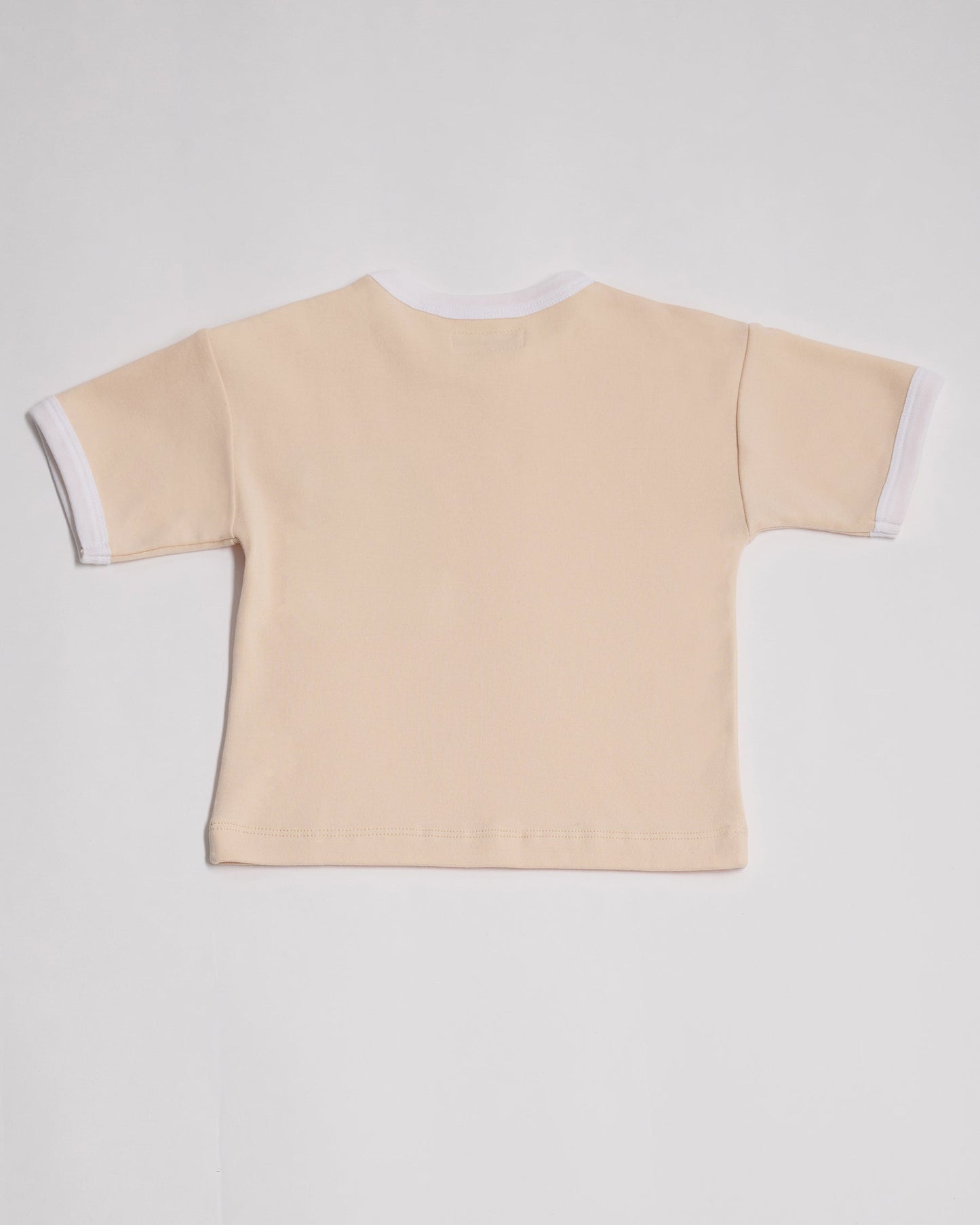 Back of vanilla coloured short sleeved t-shirt with white neck and sleeve trim.