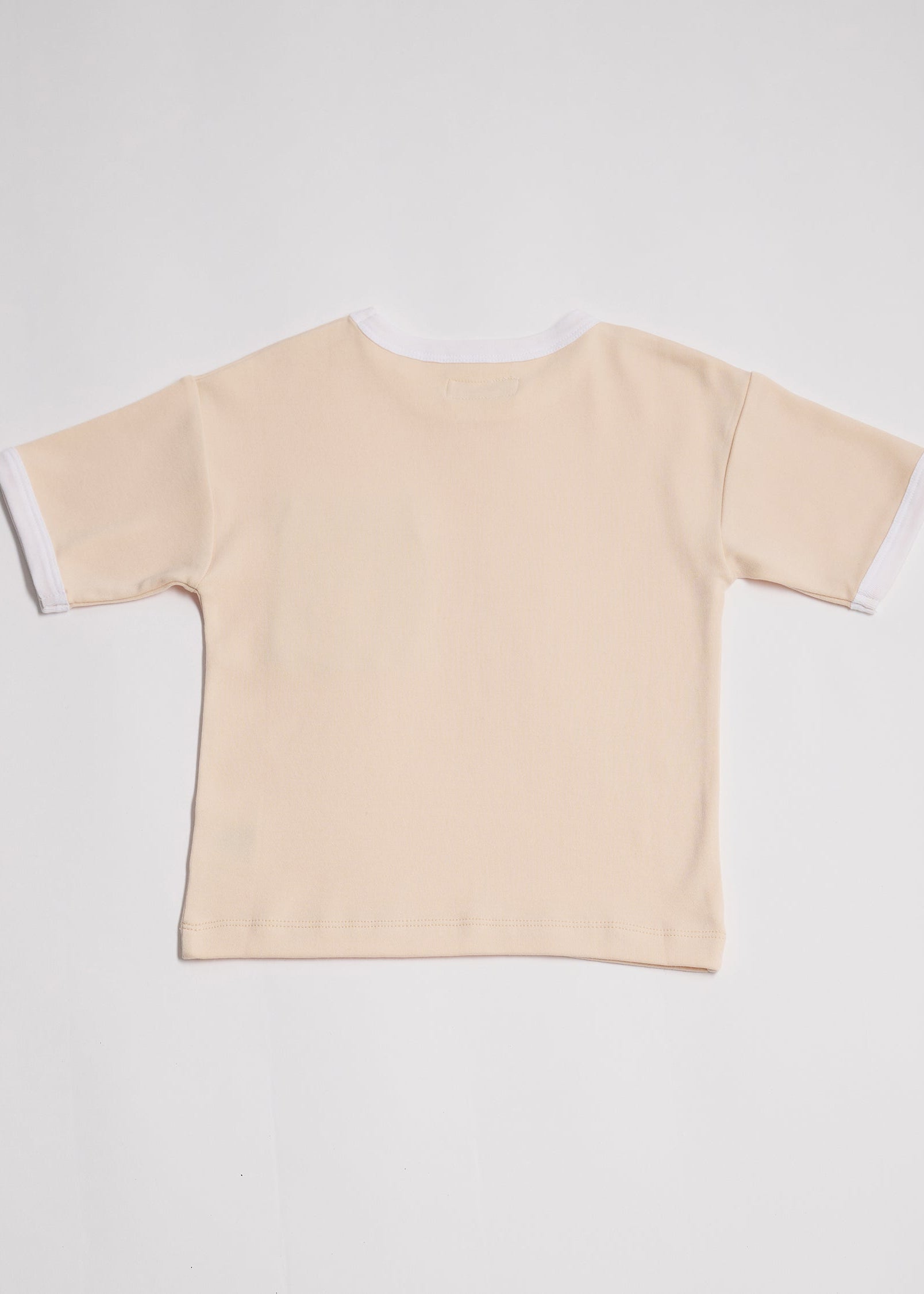 Back of vanilla coloured short sleeved t-shirt with white neck and sleeve trim.