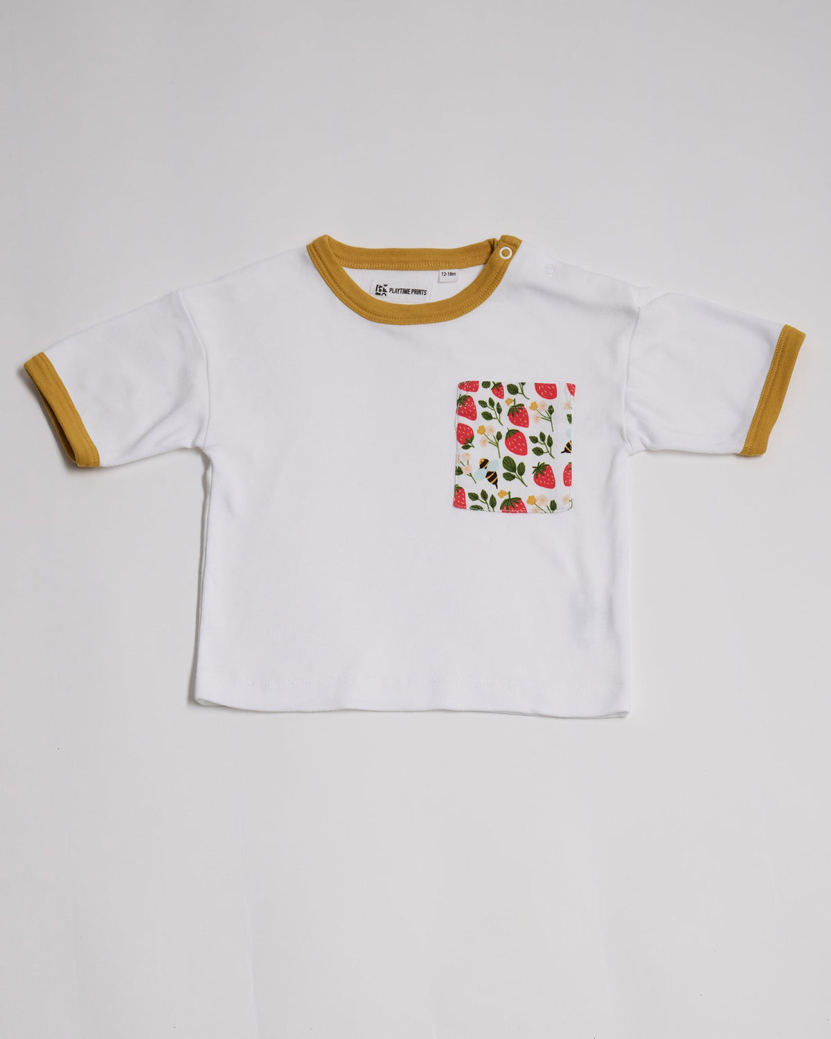 Front of white short sleeved  t-shirt with fun strawberry and bees print square chest pocket, neck poppers and honey neck and sleeve trim.