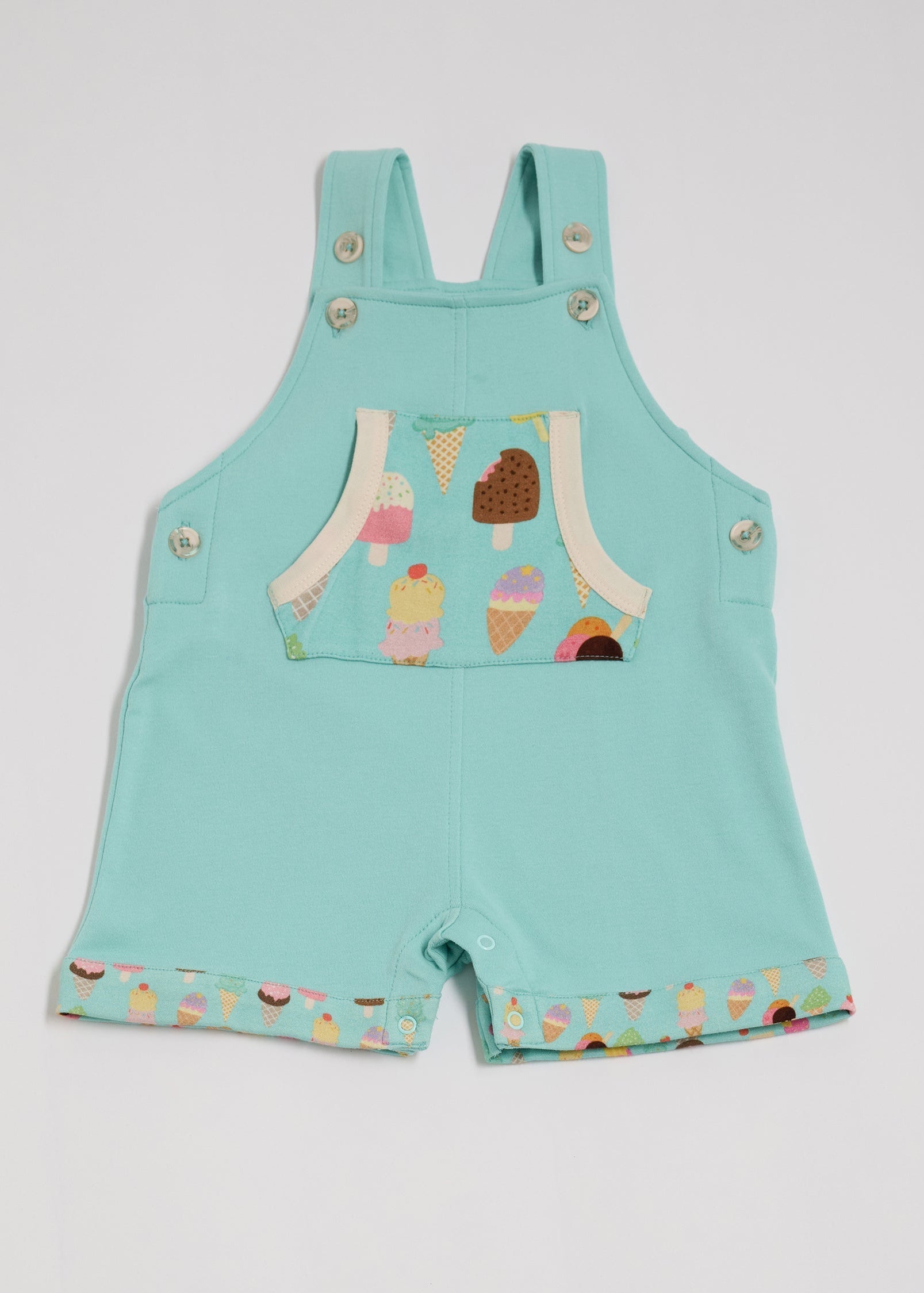 Front of turquoise short dungarees with bright ice cream print pocket and fixed turn-ups, adjustable straps, crotch poppers, vanilla buttons and vanilla trim.